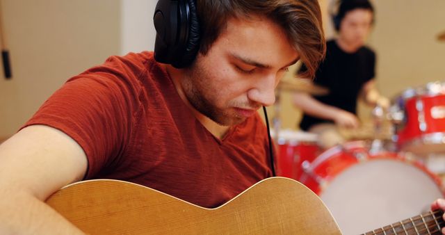 Male Guitarist Concentrating While Playing Acoustic Guitar in Studio Session - Download Free Stock Images Pikwizard.com