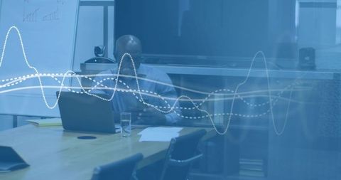 Black executive reviewing laptop documents in glass boardroom with digital data overlay