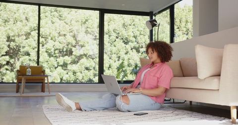 Woman Relaxing with Laptop in Bright Modern Living Room