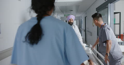 Diverse Medical Team Transporting Patient in Hospital Hallway