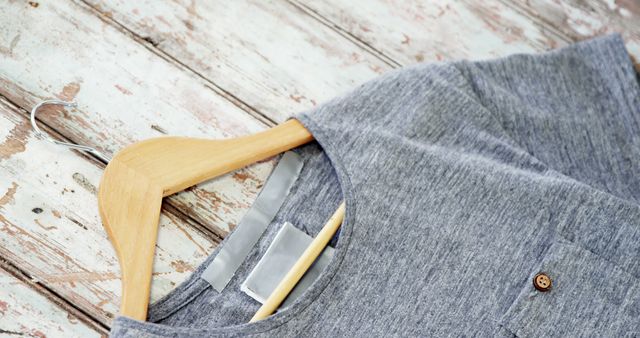 Gray T-Shirt on Wooden Hanger Over Rustic Wooden Background - Download Free Stock Images Pikwizard.com