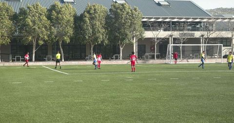 Youth soccer players prepping for goal during outdoor match