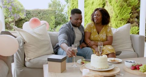 Couple Celebrating Anniversary with Champagne and Cake on Patio