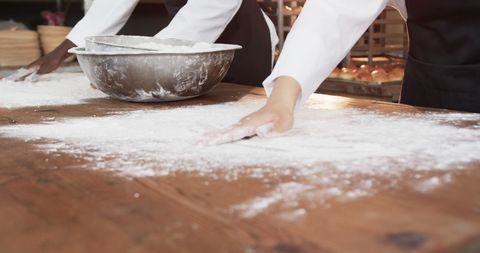 Bakers preparing floured surface in artisan bakery