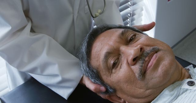 This image shows an elderly man receiving chiropractic care. The medical professional is gently supporting the patient's head, demonstrating a calm, focused environment for health and wellness treatment. Ideal for use in medical brochures, healthcare websites, or physical therapy ads emphasizing elderly care and holistic wellness practices.