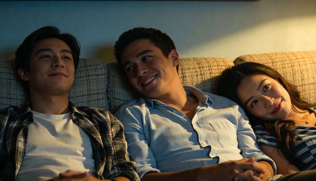 Cozy evening trio relaxing on couch, friends sharing intimate moment, casual home warmth