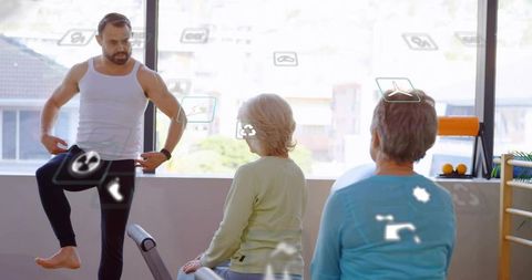 Male trainer demonstrating one-leg balance exercise for seniors in sunlit rehab studio
