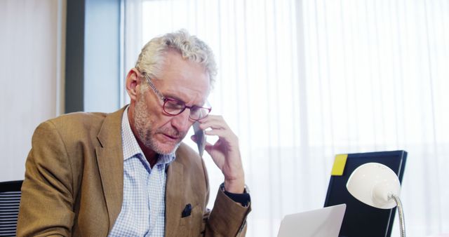 Senior businessman using smartphone and laptop in office - Download Free Stock Images Pikwizard.com