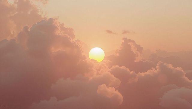 Serene Sunrise Over Fluffy Clouds with Golden Light