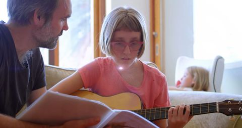 Father Teaching Daughter Guitar for Family Bonding