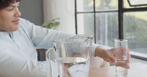 Young Man Staying Hydrated at Work in Modern Office - Download Free Stock Images Pikwizard.com
