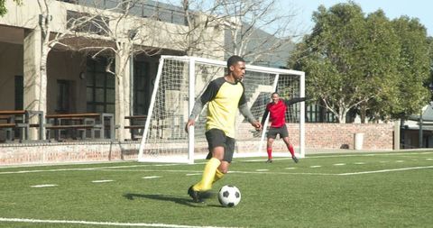 Soccer Players in Motion on Sunny Field During Match