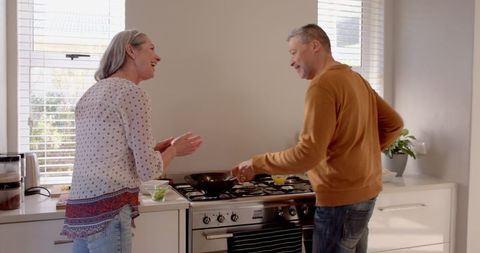Senior Couple Enjoy Time Together Cooking in Modern Kitchen