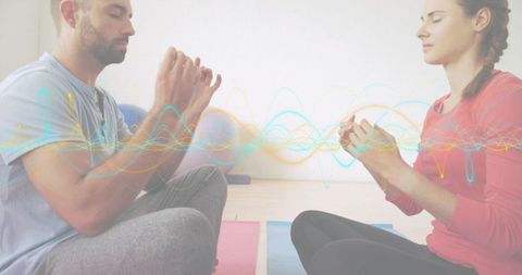 Couple meditating with energy waveform overlay on yoga mats in minimalist studio