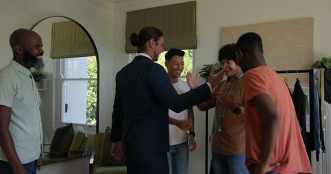 Groom Laughing with Friends in Living Room Before Wedding