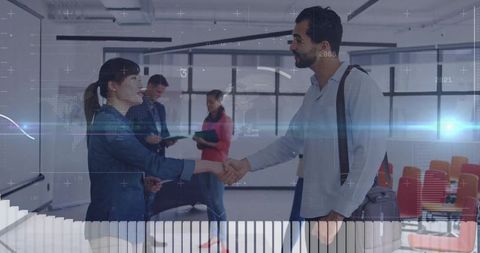 Professional colleagues shaking hands in modern office environment