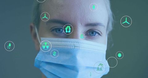 Researcher wearing mask analyzing sustainability and energy symbols