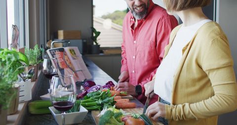 Diverse Couple Enjoys Cooking and Wine Together in Kitchen