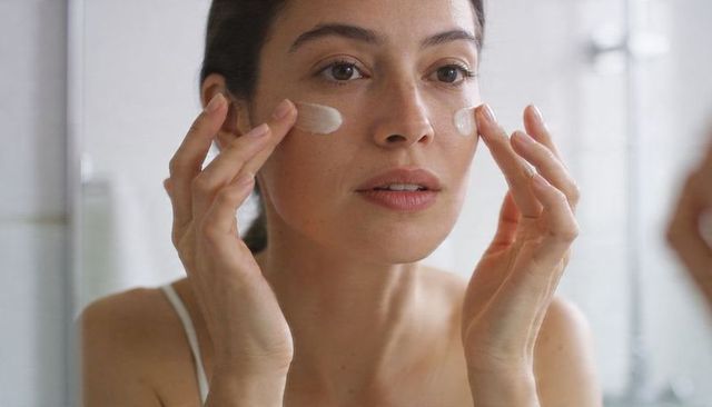 Applying undereye cream during minimalist morning skincare routine for hydrated skin