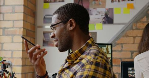 African American Businessman Communicating on Smartphone in Creative Office