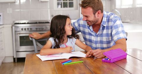 Father Helping Daughter with Coloring at Home