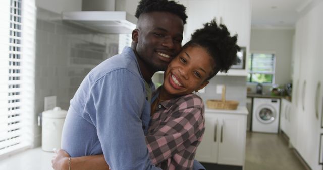 Image of happy african american couple embracing at home. love, relationship, togetherness and spending quality time at home.