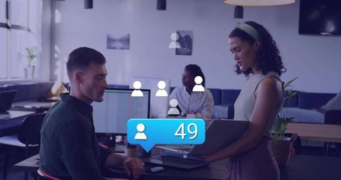 Young professionals collaborating in open-plan office with social connection notification