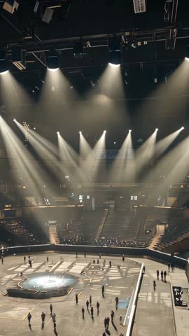 Arena lighting crew activating overhead fixtures and testing stage platform vertical video