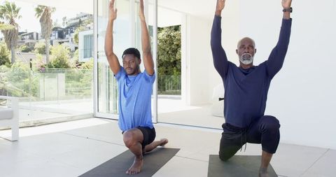 Father and Son Doing Yoga Lunges in Bright Modern Living Room