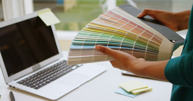 Designer Holding Color Swatches Near Laptop - Download Free Stock Images Pikwizard.com