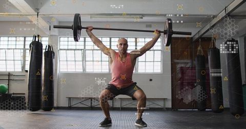 Mid-Adult Man Lifting Overhead Barbell in Industrial Gym Strength Training Session