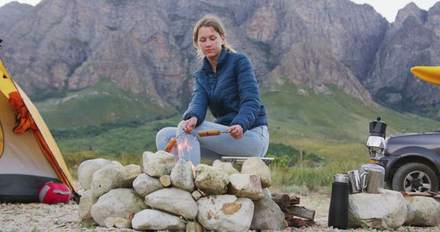 Woman cooking over campfire in scenic mountain campsite - Download Free Stock Images Pikwizard.com