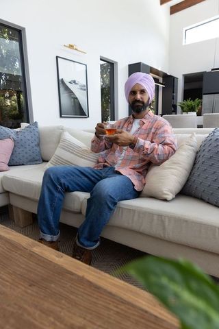 Relaxing Indian Man Enjoying Tea in Modern Living Room