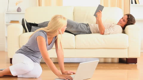 Young Couple Relaxing with Digital Devices in Cozy Living Room