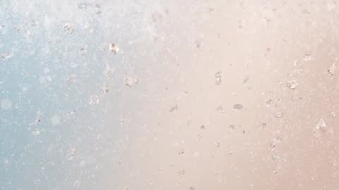 Droplets Sliding and Glinting on Glass Pane with Pastel Blue Pink Gradient Macro Motion