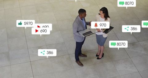 Professionals collaborating with laptop and tablet amid floating social media notification badges