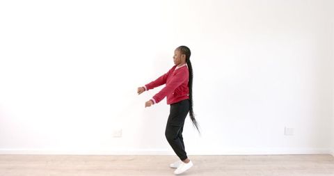 Joyful Woman Dancing in Red Jacket in Bright Minimalist Space