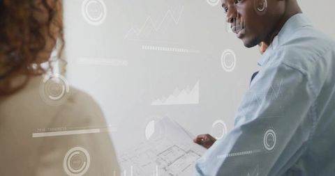 Male architect holding blueprint with digital charts