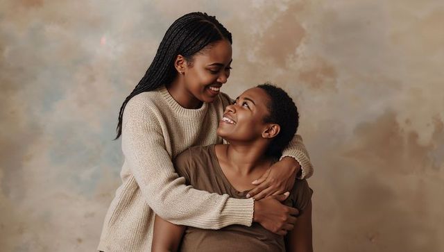 Smiling couple embracing in warm neutral tones, tender gaze and intimate studio portrait