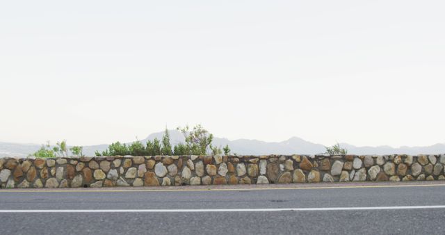 Empty Road with Stone Wall and Scenic Mountain Background - Download Free Stock Images Pikwizard.com