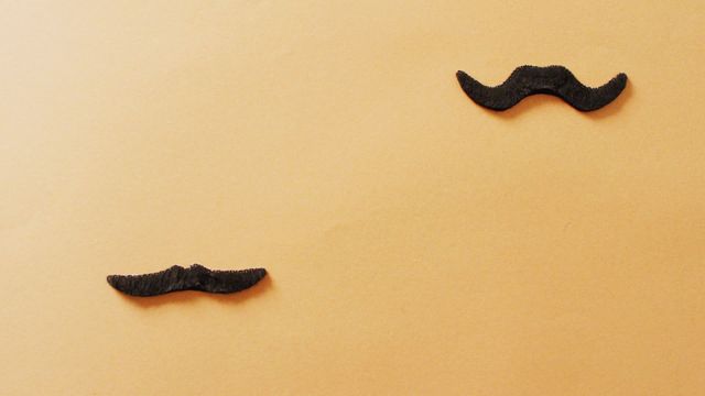 Decorative false mustaches placed on vibrant orange background, ideal for conveying playful and fun themes. Useful for creating Father's Day promotions, party invitations, or festive celebrations focused on props and costumes. Engages audiences with notions of humor and celebration through stylish, whimsical accessory color palettes.