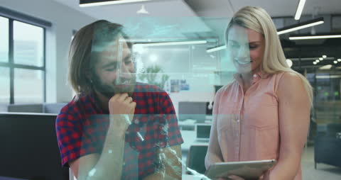 Two Professionals Analyzing Tablet with Digital Overlay in Modern Office