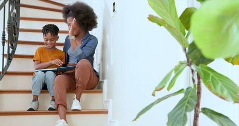 Mother and Son Reading Book Together on Stairs