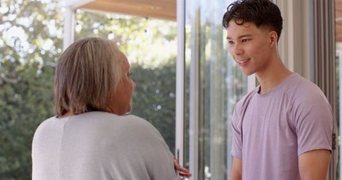 Smiling Male Engaging with Senior Woman in Bright Environment
