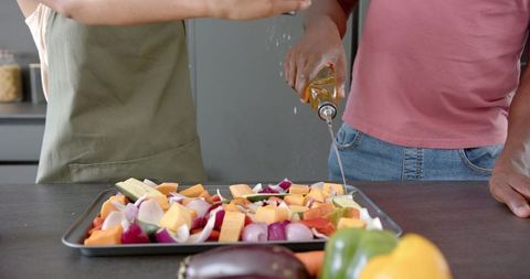 Couple Preparing Vegetables with Oil in Modern Kitchen