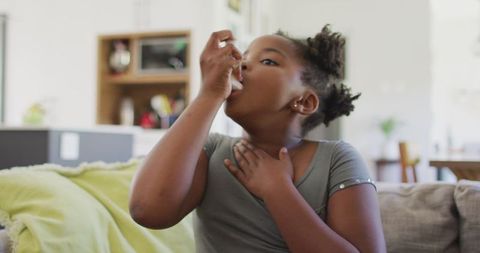 Young Girl Using Inhaler for Asthma Relief at Home