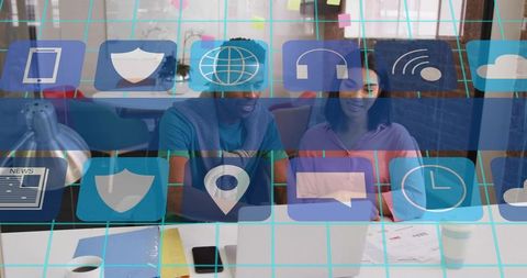 Collaborating colleagues using laptop in vibrant open-plan office with tech overlay