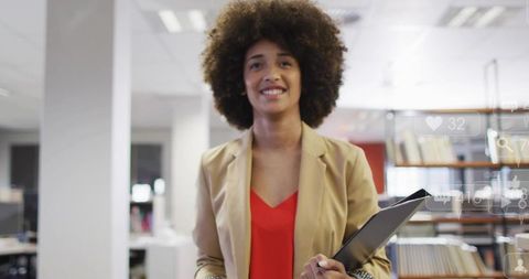 Confident businesswoman holding tablet smiling in modern office with digital overlays