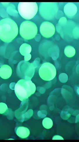 Vertical abstract video showing pulsing green bokeh lights drifting in soft-focus loop