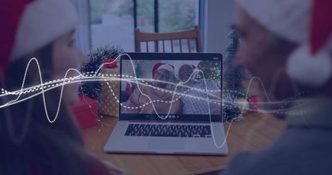 Family Holiday Video Call Connecting Generations via Laptop with Santa Hats and Tinsel